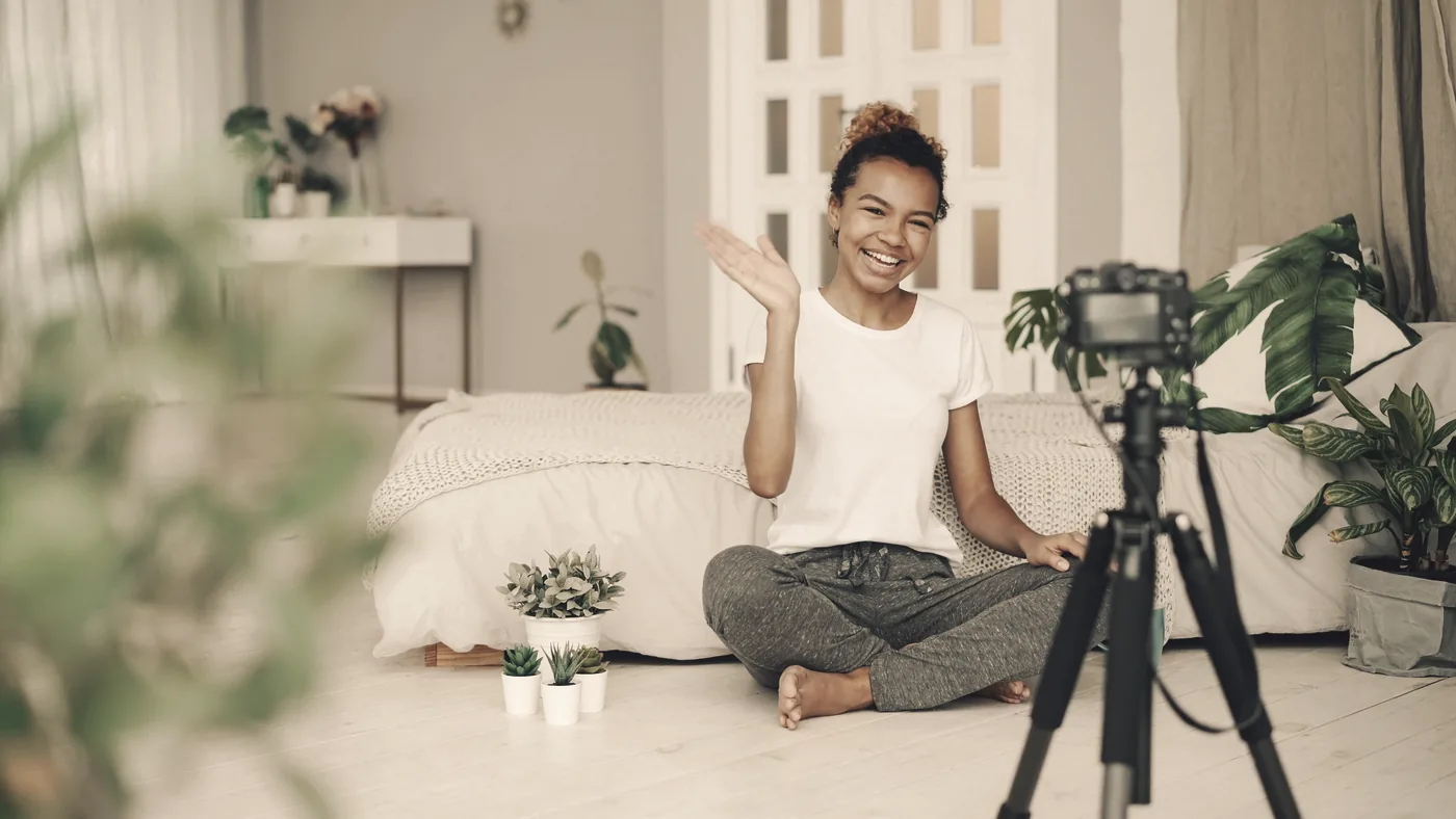 Kvinna som spelar in en film med kamera på stativ