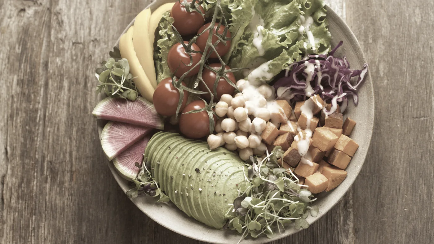 Skål med avokado, kikärter, tomater, rödkål och groddar